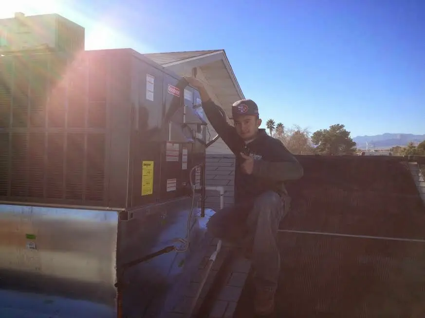 HVAC technician performing Air Duct Cleaning on a rooftop unit in Mayfield Heights